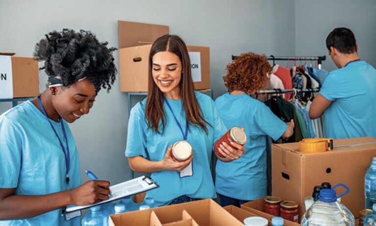 Happy workers packing food into boxes