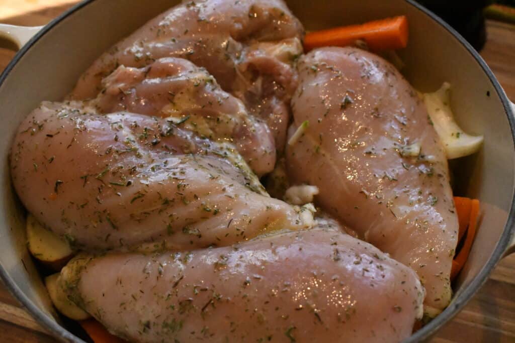 A Dutch Oven with seasoned raw chicken