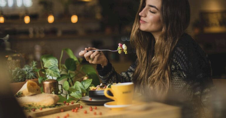 A young woman eating pasta salad